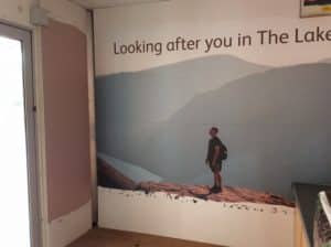 One of the wall decals, showing a man standing on a rock. Above him reads "Looking after you in The Lake-"