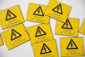 Several signs with the electricity danger symbol and "Danger, Live Busbars" on them.