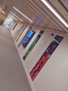 A Dutch angle on several Perspex panels lining a hallway.