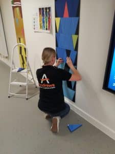 A woman installing a blue Perspex panel.