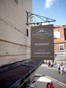 Hanging sign for the Corner Grill House.