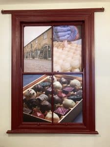 A window-shaped sign with pictures of chocolate in the panes.