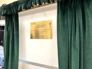 A brass plaque framed by green curtains.