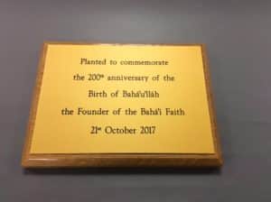 A yellow aluminium sign commemmorating the 200th anniversary of the founder of the Baha'i faith.